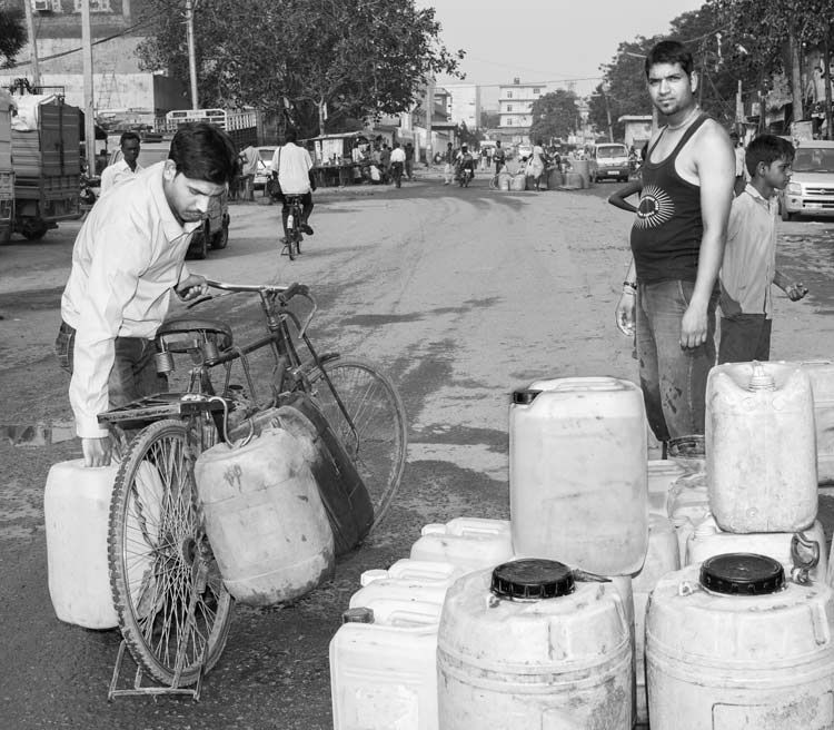 Men and Drinking Water Procurement - Transporting jerrycans home after filling them with water from a tanker in an unsettled colony in South East district, National Capital Territory of Delhi